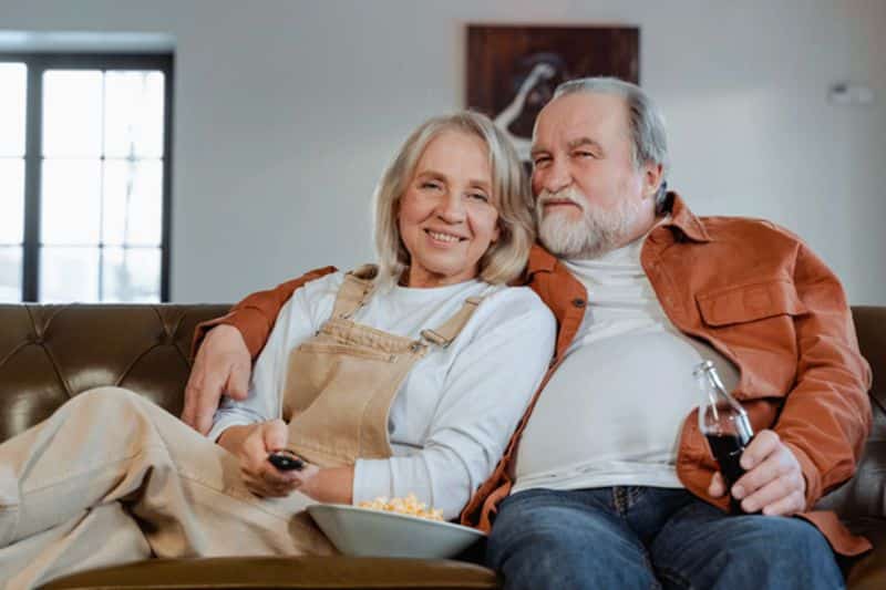 Senior couple relaxing on a couch in a shared home